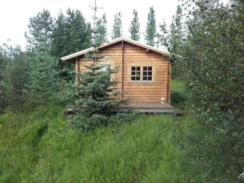 a small wooden cabin in the middle of a field at Arngrimslundur log cabin - cabin 3 in Fludir