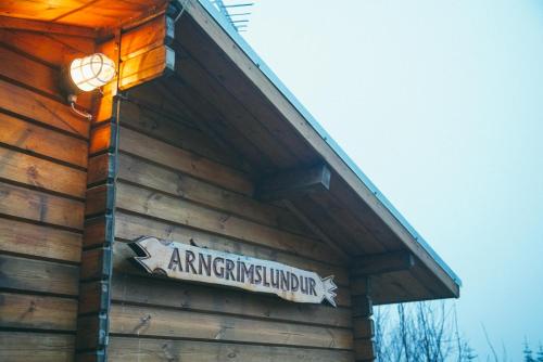 un panneau sur le côté d'un bâtiment dans l'établissement Arngrimslundur log cabin - cabin 3, à Fludir