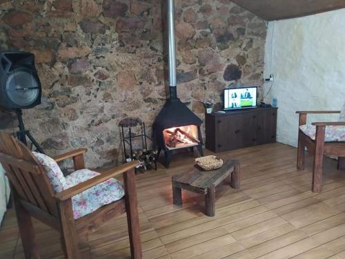 a living room with a fireplace in a stone wall at El Destacamento in Villa Serrana