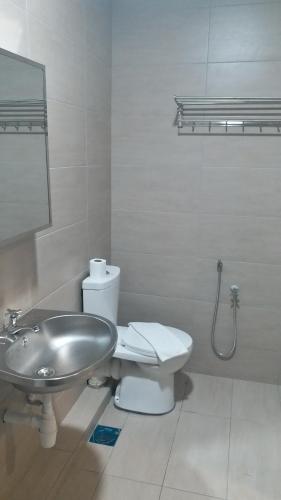 a bathroom with a sink and a toilet at Blue Eyes Hotel in Kepala Batas