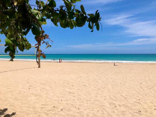 una playa con gente en la arena y el océano en At Wind Chimes Boutique Hotel en San Juan