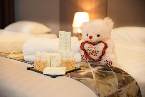 a teddy bear sitting on a bed with a tray with candles at Cosy private suite 2BR 591 Nexus USJ Shah Alam in Shah Alam