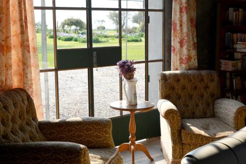 a living room with two chairs and a table and a window at Estancia El Cangue in Porvenir