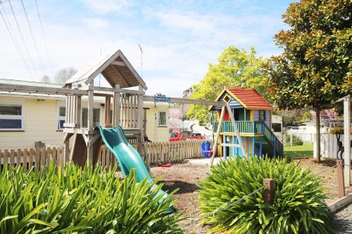 a playground with a slide in a yard at Orere Point Top 10 Holiday Park in Auckland