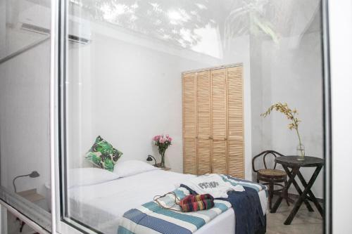 a small bedroom with a bed and a glass wall at 50N15 B&B in Cali