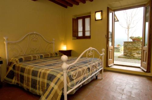 ein Schlafzimmer mit einem Bett und einem großen Fenster in der Unterkunft Comfortable apartment in the heart of the Tuscan countryside in Pulicciano