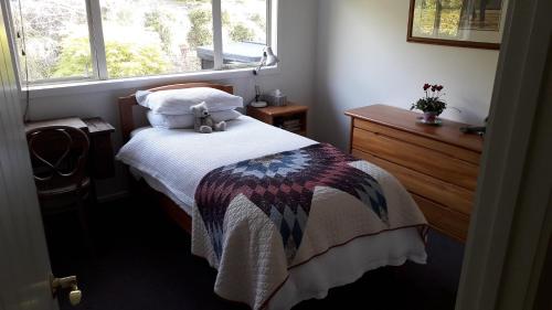 um quarto com uma cama com um urso de peluche em Shurinji em Whanganui