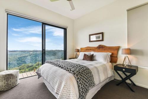a bedroom with a bed and a large window at The Ridge at Maleny in Maleny