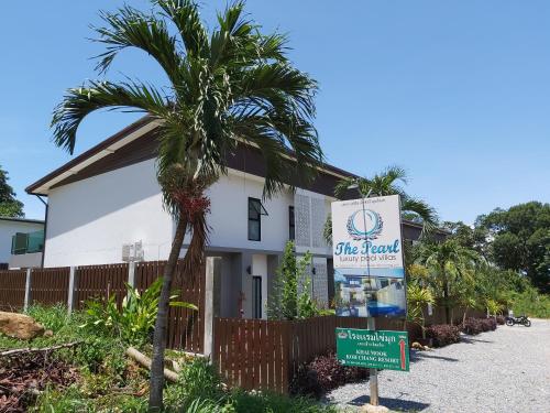 a sign in front of a building with a palm tree at The Pearl Luxury Pool Villas in Ko Chang