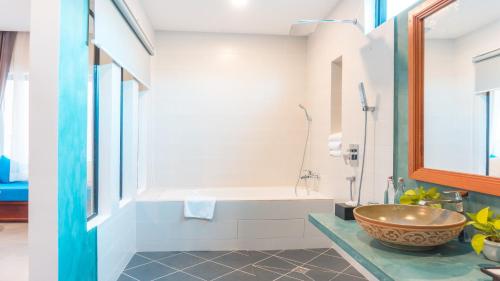 a bathroom with a tub and a sink with a bowl at Angkor Aurora in Siem Reap