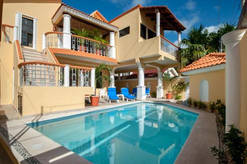 a villa with a swimming pool in front of a house at Righetto Vacation Rentals in Puerto Morelos