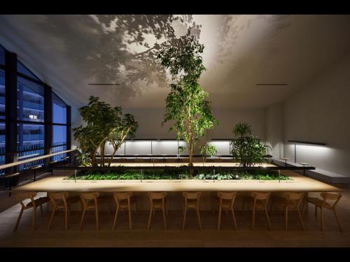 a large table with chairs and trees in a room at 9h nine hours Hakata station in Fukuoka