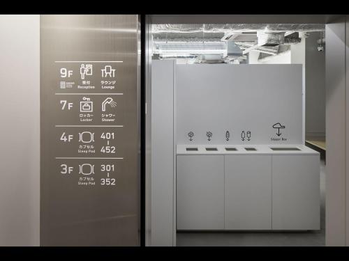 a glass door with writing on it next to a stove at 9h nine hours Hakata station in Fukuoka