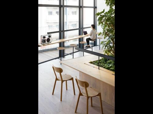 a person sitting at a table in a room with a window at 9h nine hours Hakata station in Fukuoka