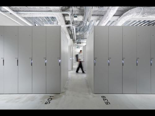 a person walking through a row of white lockers at 9h nine hours Hakata station in Fukuoka