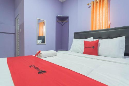 Un dormitorio con una cama con una manta roja. en RedDoorz @ Gatot Subroto Street Bandung 3, en Bandung
