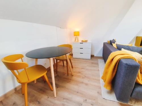 een woonkamer met een tafel en stoelen en een bank bij Yellow Studio in Bergen