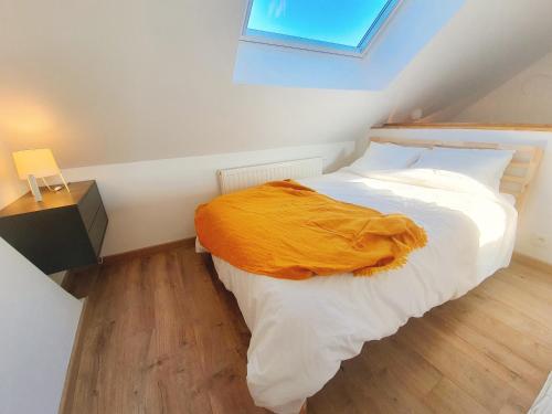 ein Schlafzimmer mit einem Bett mit einer gelben Decke darauf in der Unterkunft Yellow Studio in Mons