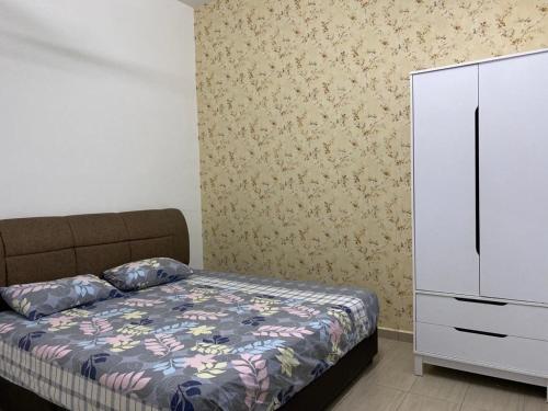 1 dormitorio con 1 cama y vestidor blanco en Homestay ayer keroh mitc en Melaka