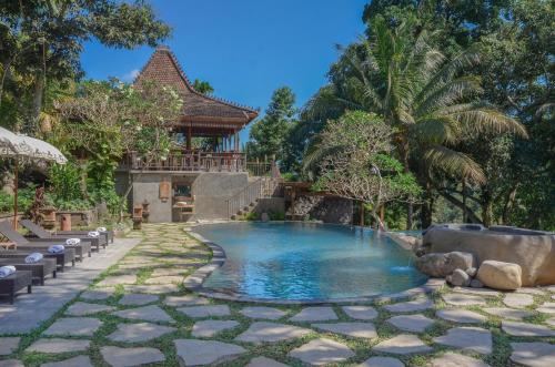 a swimming pool in a backyard with a resort at Bucu View Resort in Ubud
