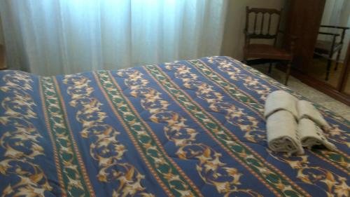 a bed with a blue comforter with towels on it at B&B In Centro in San Benedetto del Tronto