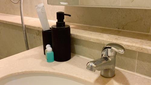 a black soap dispenser sitting on top of a bathroom sink at luxury high floor loft pool condo with 2 bedrooms in Chiang Mai