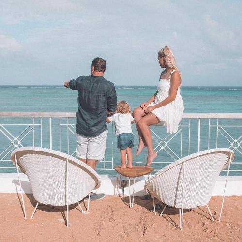a woman and a man and a child on the beach at Canonnier Beachcomber Golf Resort & Spa in Pointe aux Cannoniers