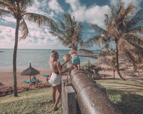 a woman and two children looking at the beach at Canonnier Beachcomber Golf Resort & Spa in Pointe aux Cannoniers