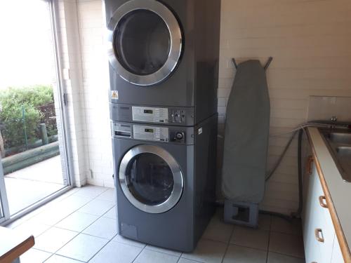 two washing machines in a kitchen next to a sink at Crest Motor Inn in Queanbeyan