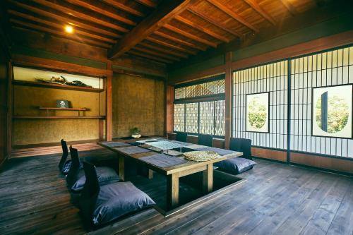 a room with a table and chairs in it at Kominkayado LOOF Okanoie in Yamanashi
