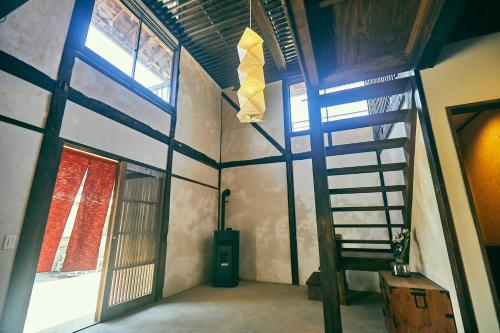 a room with a ladder and windows in a building at Kominkayado LOOF Okanoie in Yamanashi