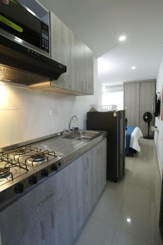 a kitchen with a sink and a stove top oven at New Studio Apartment for Two in Medellín