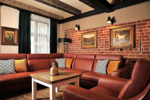 a living room with a couch and a brick wall at Apartamenty Żeglarska 25 in Toruń