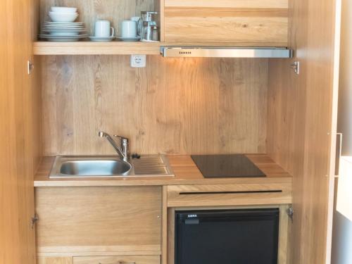 a small kitchen with a sink and a microwave at Hotel Lutter in Munich