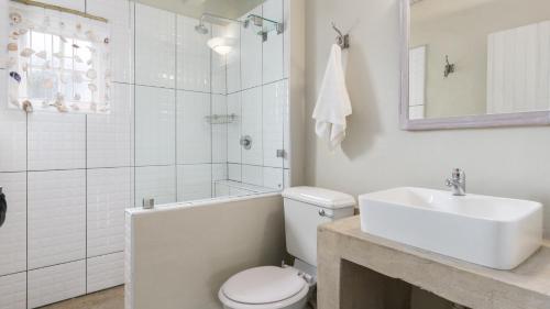 a bathroom with a sink and a toilet and a bath tub at Blue Bay Lodge in Saldanha