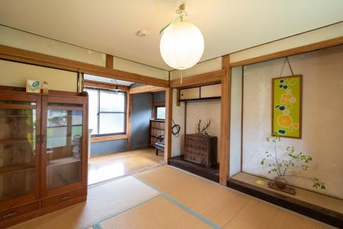 a living room with a hallway with a chandelier at Hostel 東風ノ家（Kochi-no-ya） in Aki
