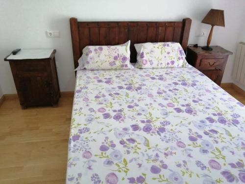 ブロトにあるCompleto Brotoの花柄の掛け布団と枕2つが備わるベッド1台