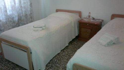 a bedroom with two beds and a wooden nightstand at B&B In Centro in San Benedetto del Tronto