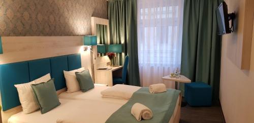 a bedroom with a bed with a blue headboard at Hotel Budapester Hof in Hamburg