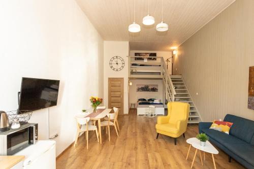 een woonkamer met een bank en een tafel en stoelen bij Horský dom apartmány 2 in Levoča