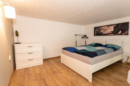 ein Schlafzimmer mit einem Bett und einer Kommode darin in der Unterkunft Horský dom apartmány 2 in Levoča