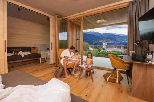 a man and two children sitting in a hotel room at Tratterhof Mountain Sky Hotel in Maranza