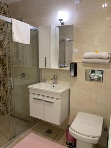 a bathroom with a toilet and a sink and a shower at Agora Studios in Plovdiv