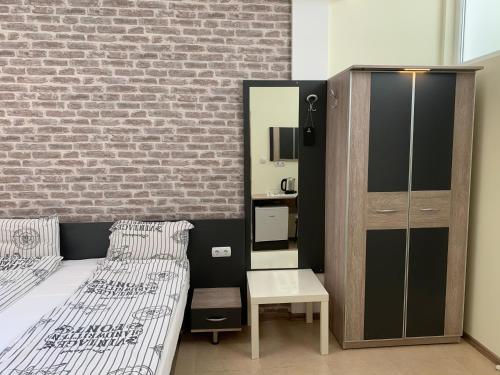 a bedroom with two beds and a brick wall at Agora Studios in Plovdiv