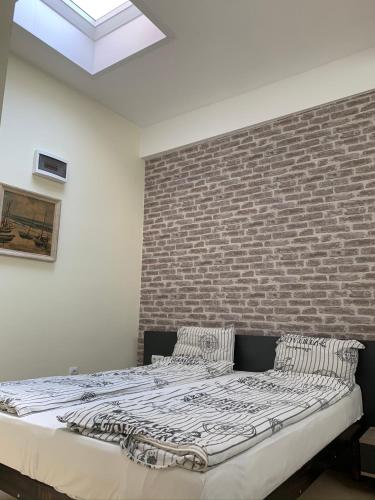 a bed in a room with a brick wall at Agora Studios in Plovdiv