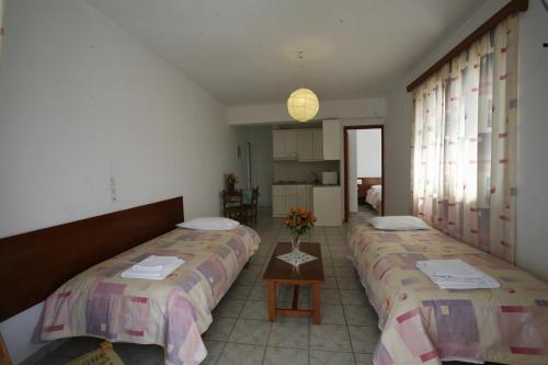 マルマリにあるGikas Apartmentsのベッド2台と花のテーブルが備わる客室です。