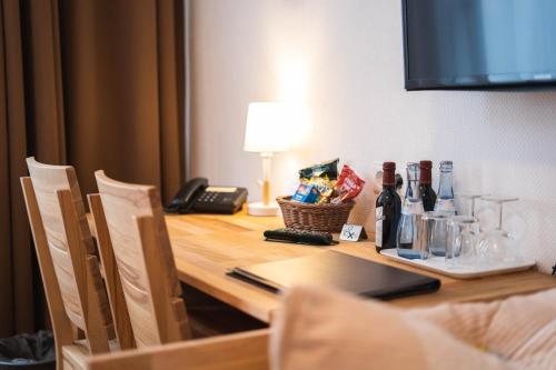 una mesa con teléfono y botellas de vino. en Pension am Heusteig, en Stuttgart