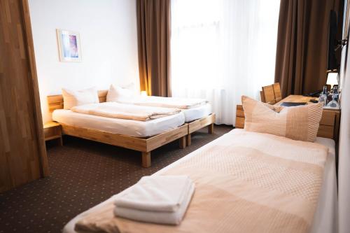 a hotel room with two beds and a window at Pension am Heusteig in Stuttgart