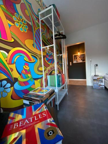 a living room with a colorful wall with a ladder at Planet Gast - Beatles-Wohnung in Marklohe