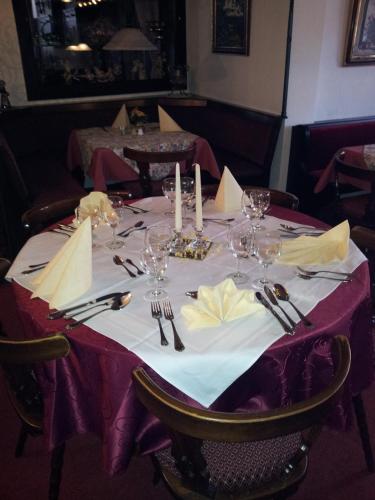 a table with wine glasses and napkins on it at Hotel Weinhaus Am Stiftstor in Treis-Karden